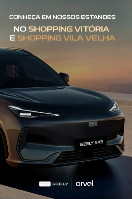 “Fachada moderna da nova unidade da concessionária Dealer Geely ao entardecer, com reflexo do pôr do sol nas amplas janelas espelhadas. Em destaque, o texto ‘Conheça nossa unidade – A Dealer Geely chegou’, acompanhado do logotipo da Geely Dealer no canto inferior direito.